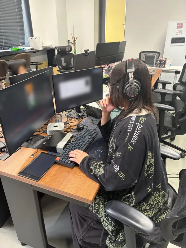ヘッドセットを着けたスタッフが、2台のモニターの前でキーボードを操作している様子